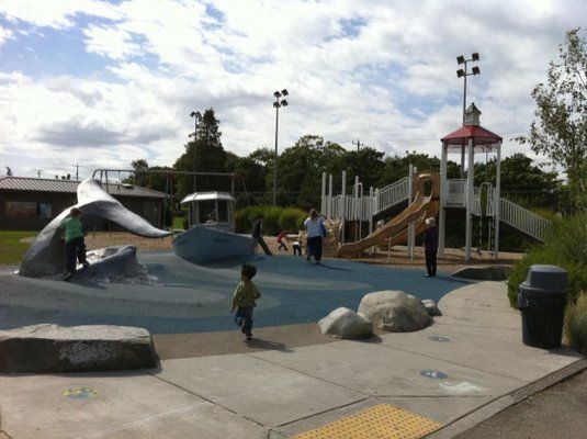 A photo of a playground with a statue of a whale's tail
